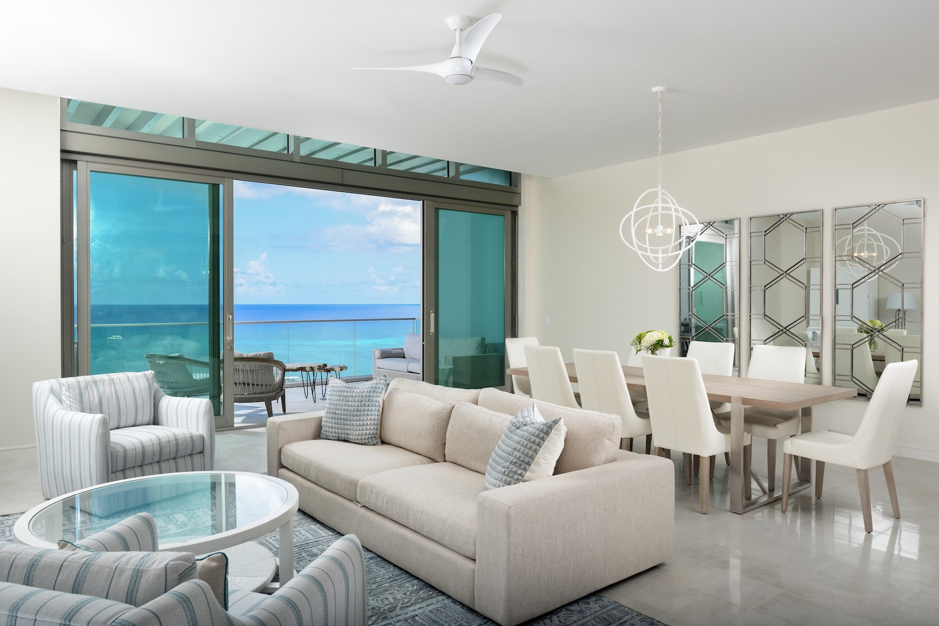 Open Plan living room and dining room with open patio doors overlooking the caribbean sea 